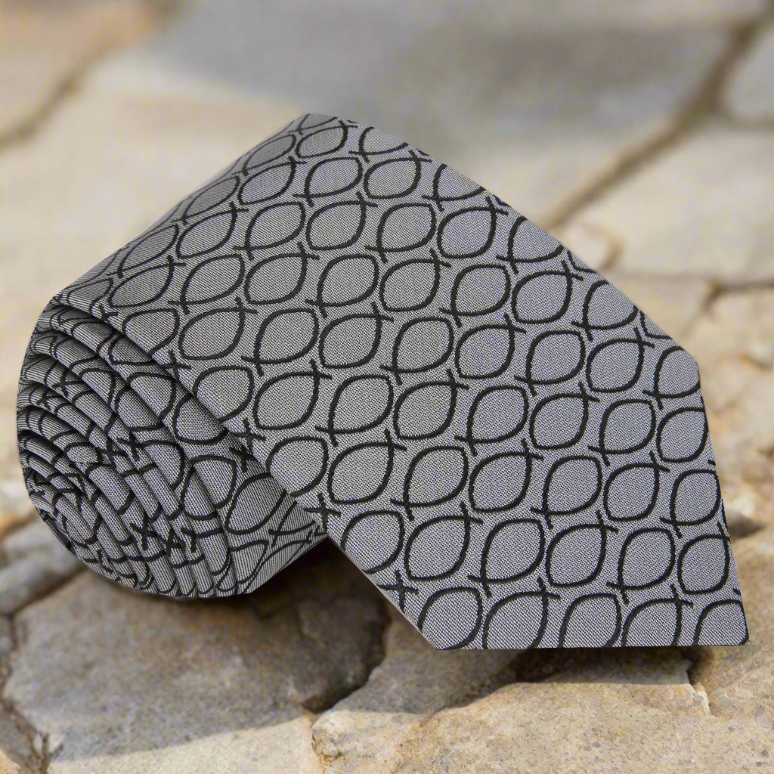 Elegant Ichthys Christian necktie displayed with a matching pocket square, highlighting the intricate fish symbols.