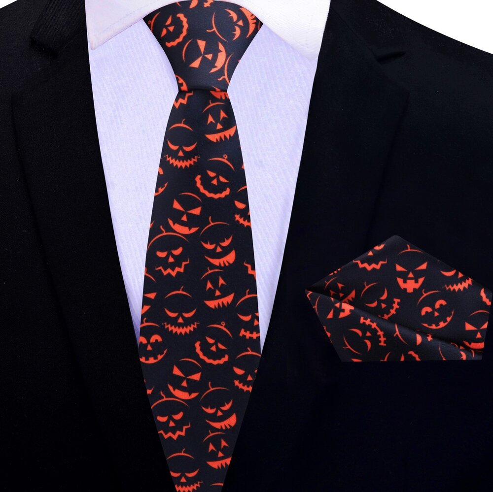 Model wearing a jack-o-lantern necktie at a Halloween party, complementing a navy suit.