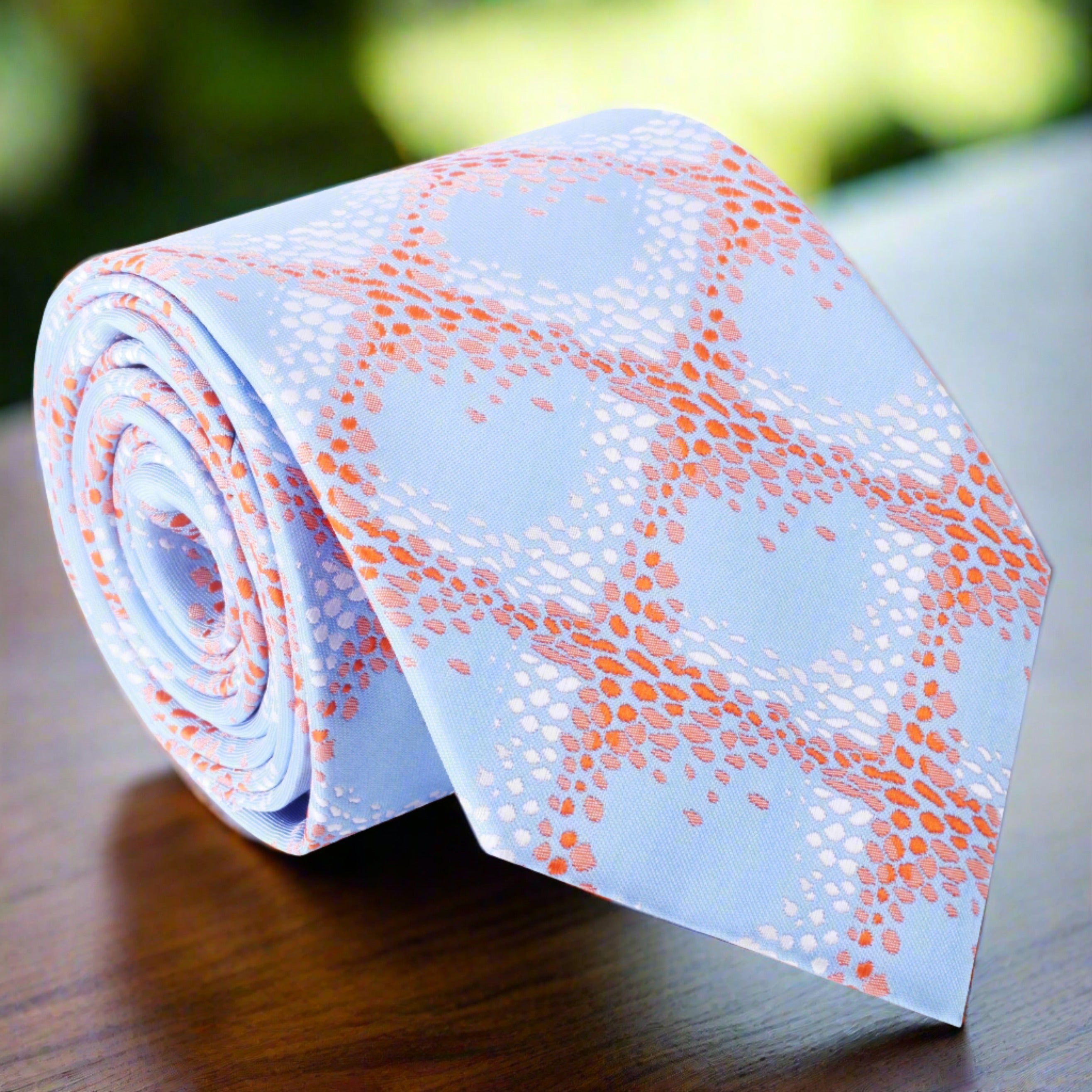Close-up of the Abstract Elegance Silk Tie showcasing its geometric pattern in light blue and orange.