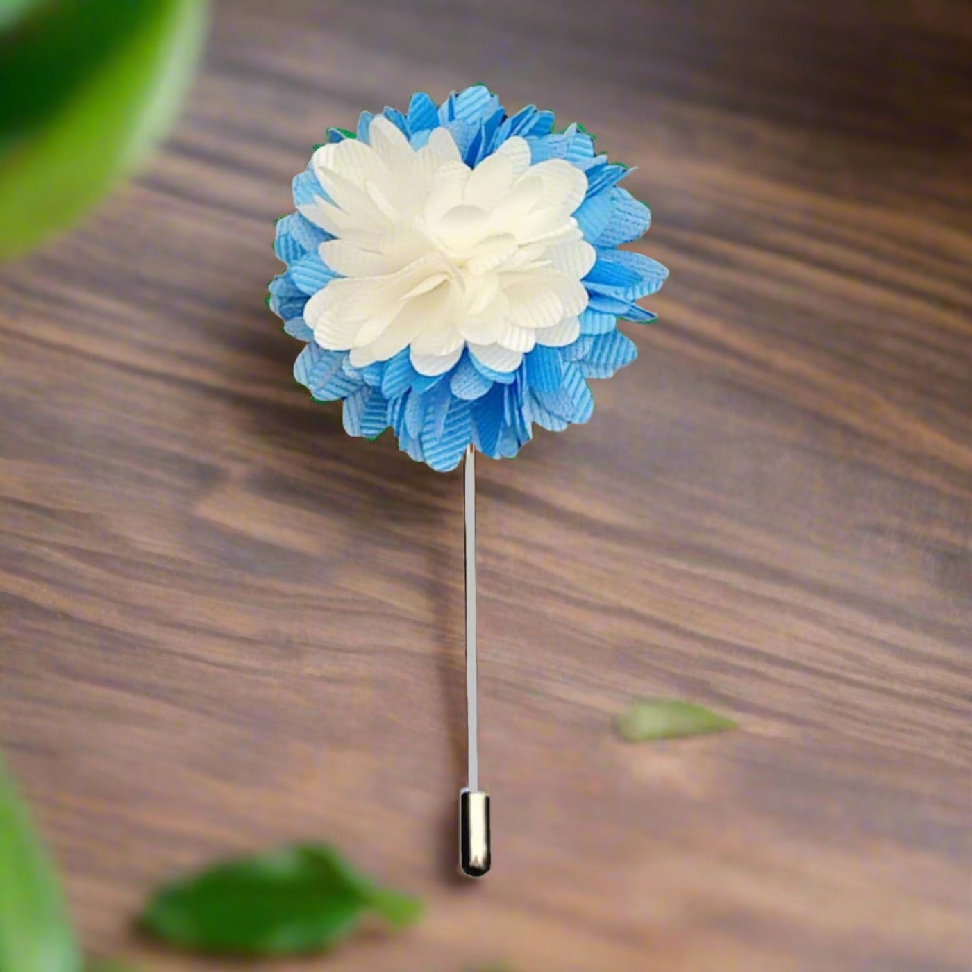 Close-up of the Regal Blossom flower pin showing intricate stitching and soft light blue petals.