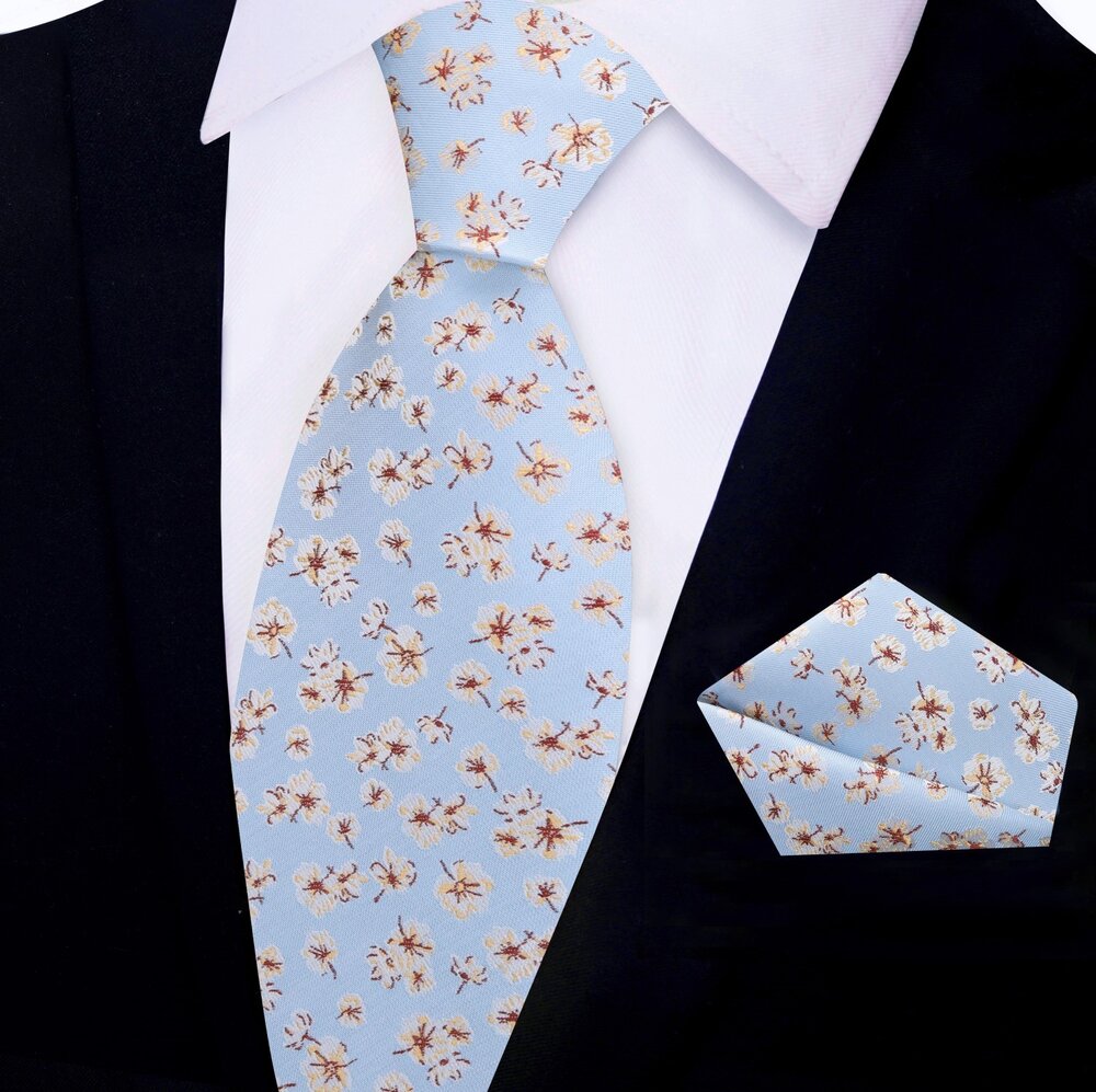 Groom wearing a light blue wedding tie with cream and burgundy floral design