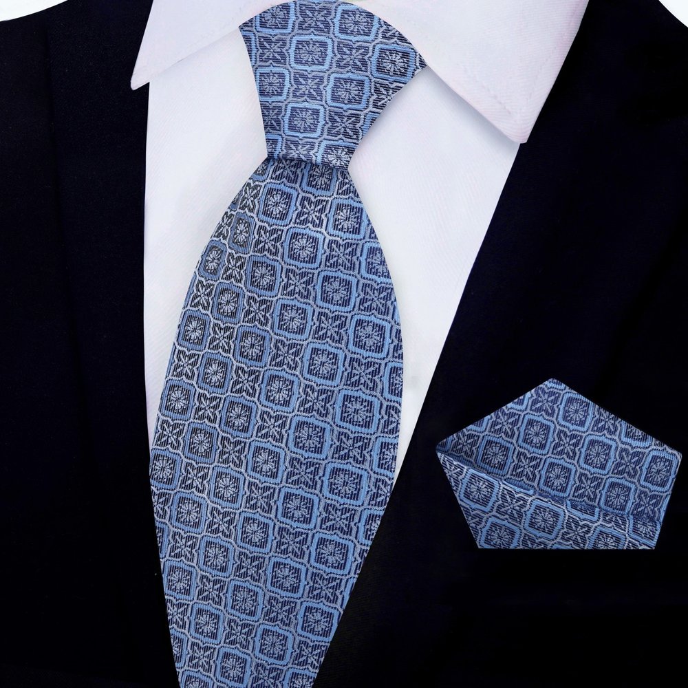 Silk necktie in peach pink with modern geometric design paired with formal suit