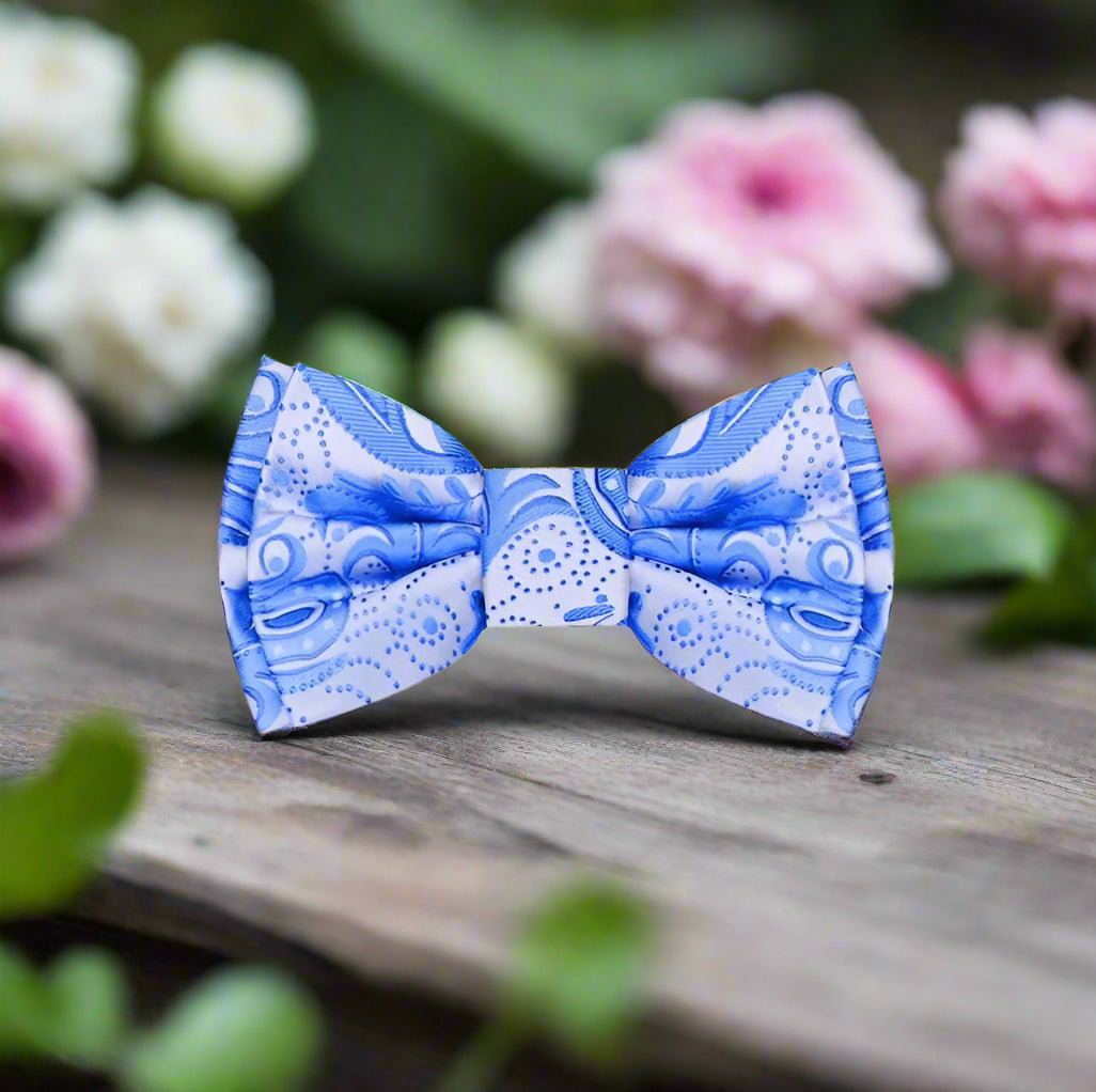 Light blue paisley silk bow tie displayed against a crisp white background.