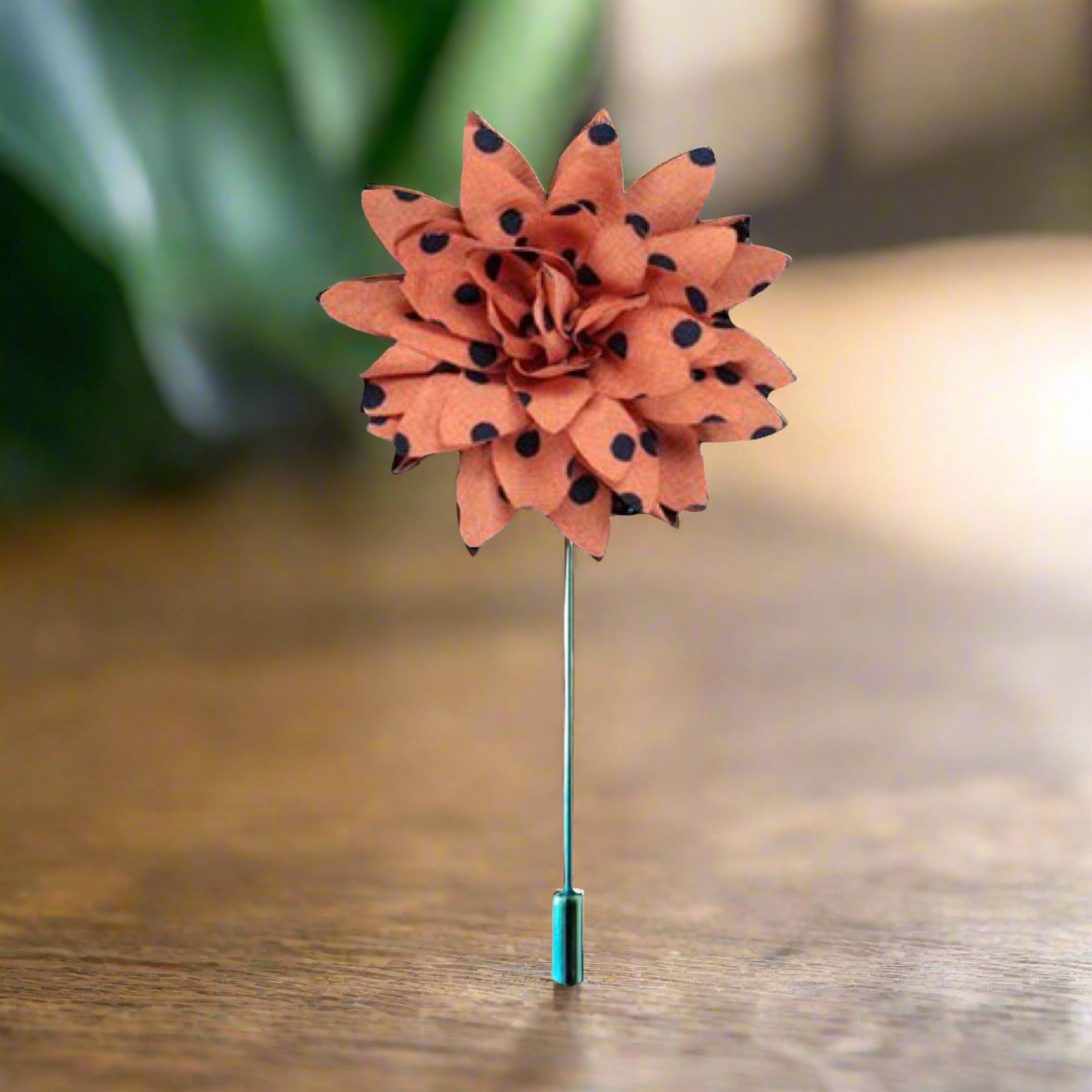 Front view of vibrant orange flower lapel pin on a suit jacket.
