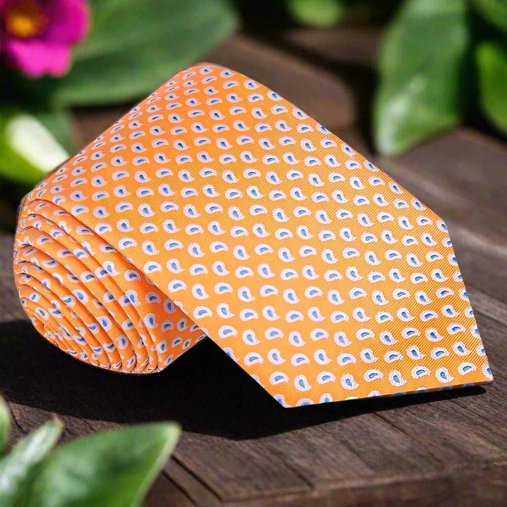 Mens necktie with a stylish paisley pattern in shades of orange and blue