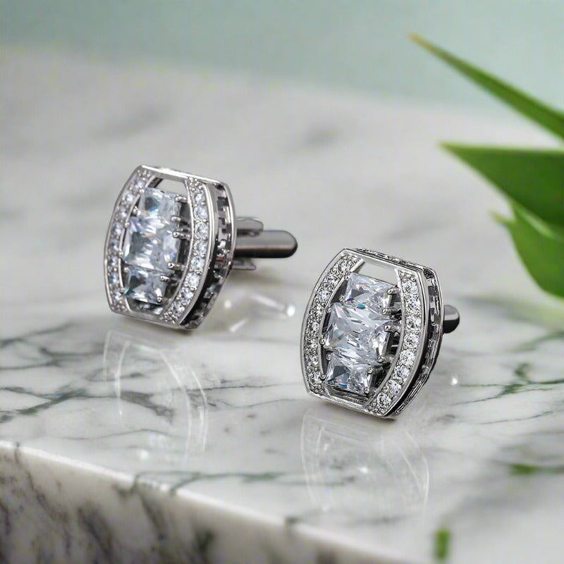 Elegant chrome oval cufflinks with clear stones on a formal shirt