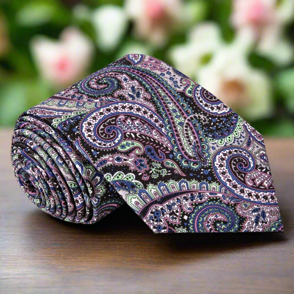 Close-up view of vibrant paisley tie featuring intricate patterns in green, purple, pink, and brown, perfect for formal events.