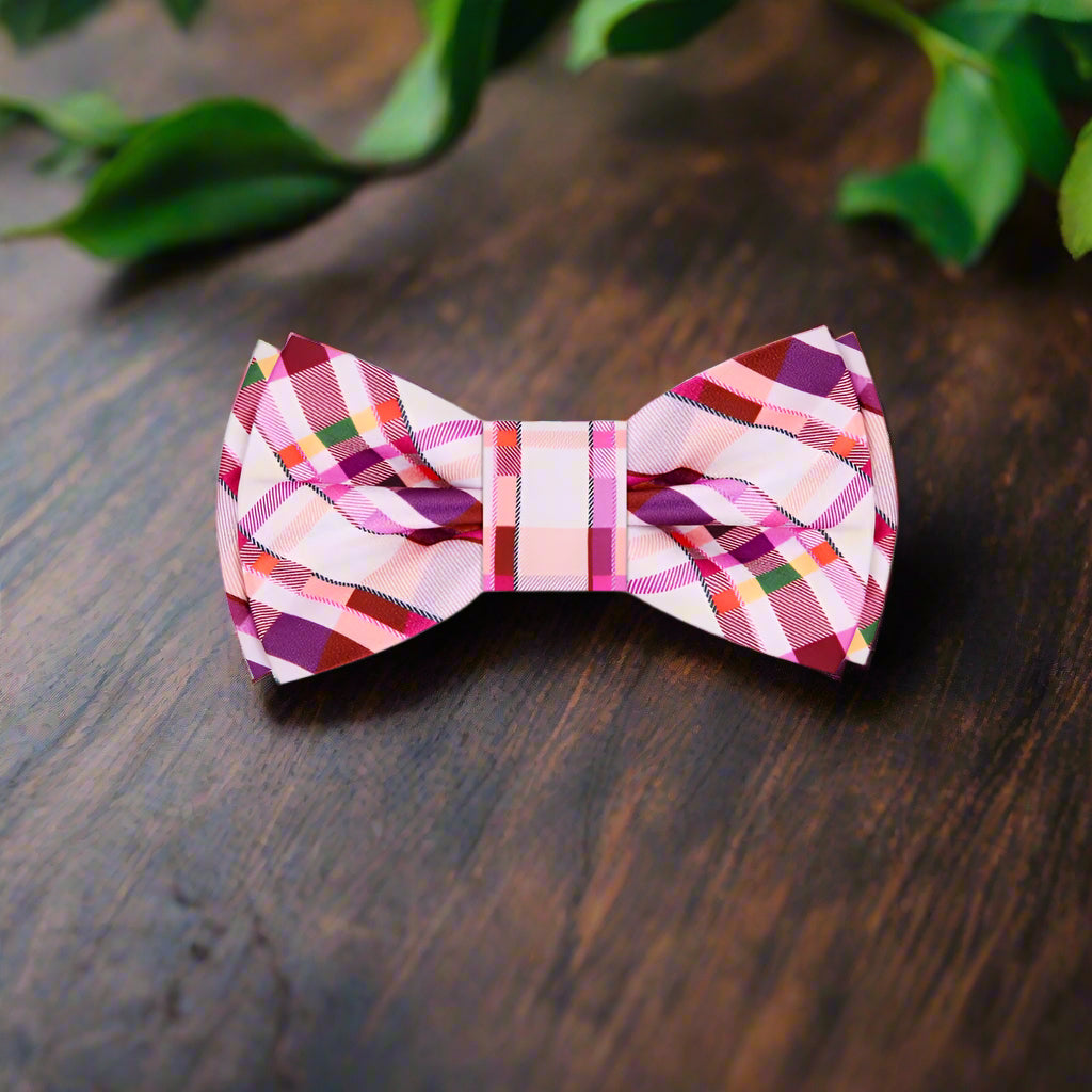 Model wearing a stylish plaid bow tie paired with a white dress shirt and navy suit.