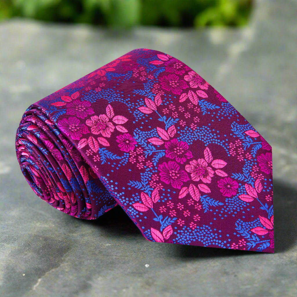 Close-up of charming purple floral necktie showcasing light blue and pink flower patterns.