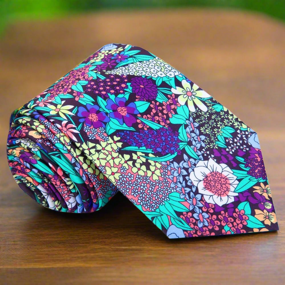 Close-up of silk tie with botanical pattern in green, purple, and teal—perfect floral necktie for garden weddings.