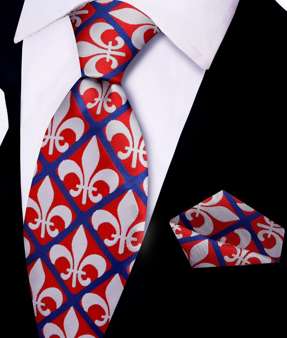 Close-up of fleur-de-lis tie and pocket square set on a wooden table.