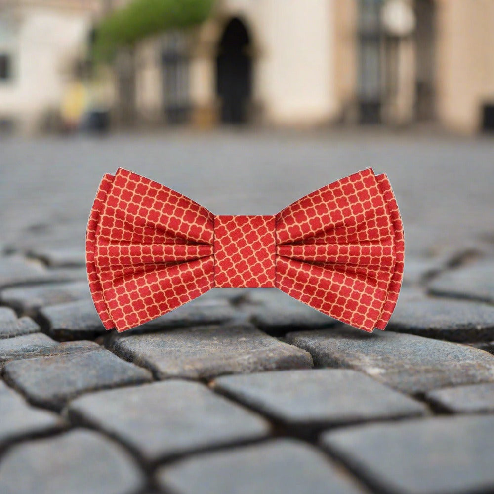 Elegant red bow tie with gold quatrefoil pattern on a tuxedo for black-tie events