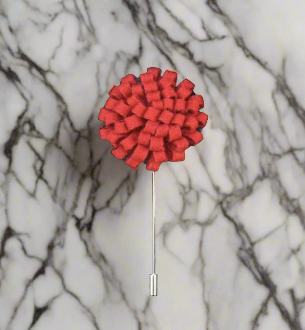 Red Knit Burst Lapel Flower Pin against a formal suit Red Knit Burst Lapel Flower Pin against a formal suit