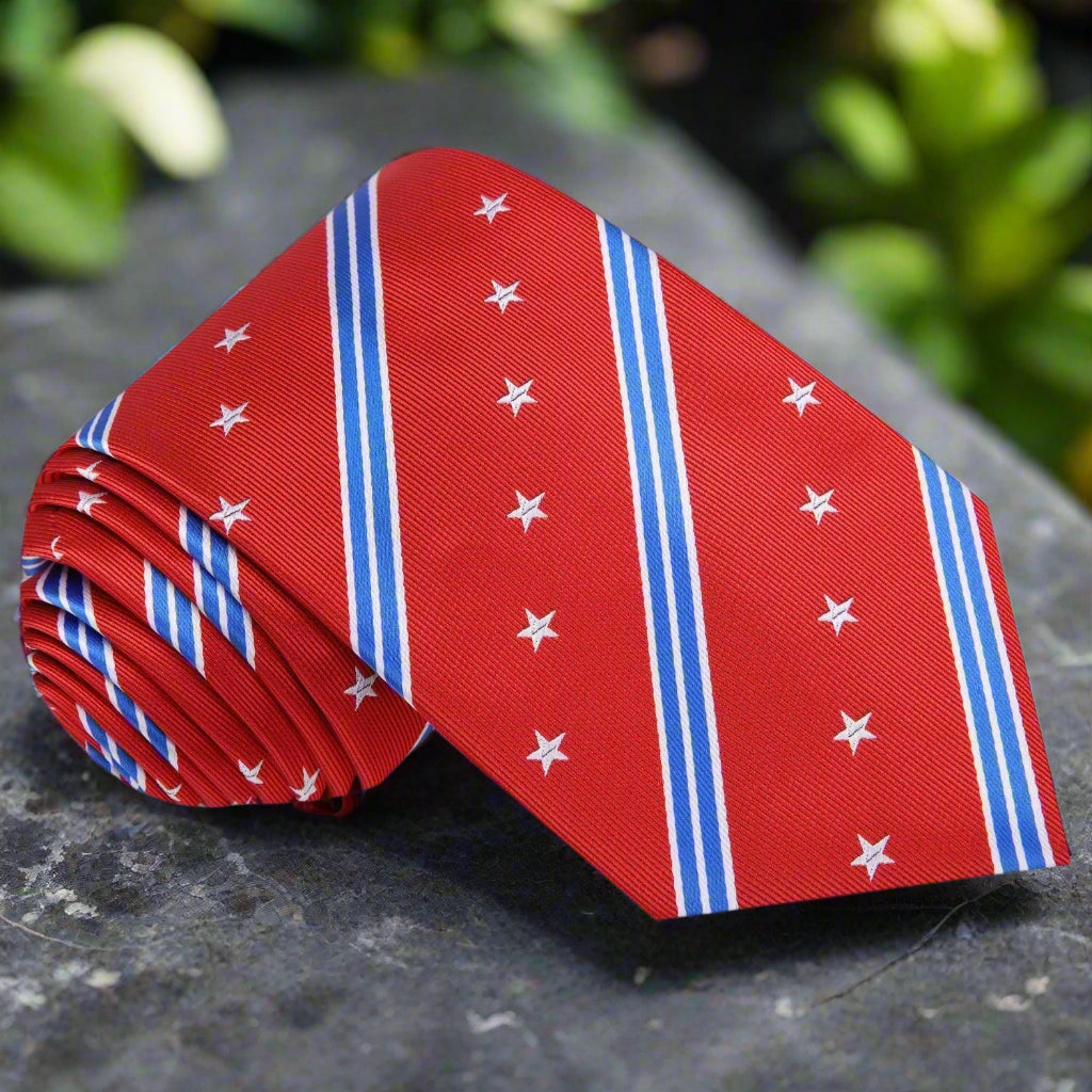 Stars and stripes patriotic necktie draped over a suit jacket, showcasing its vibrant colors and silk texture.