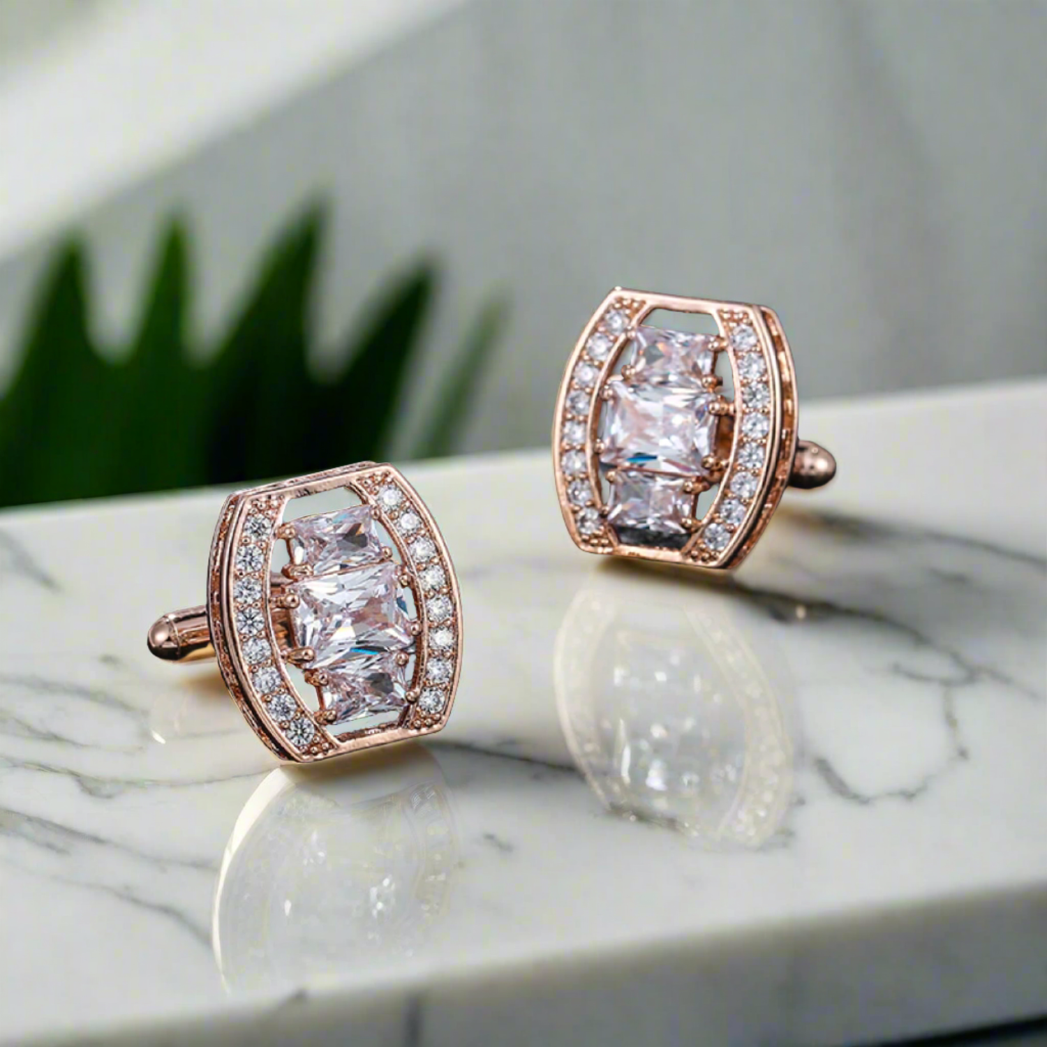 Close-up of elegant rose gold oval cufflinks with clear gemstone.
