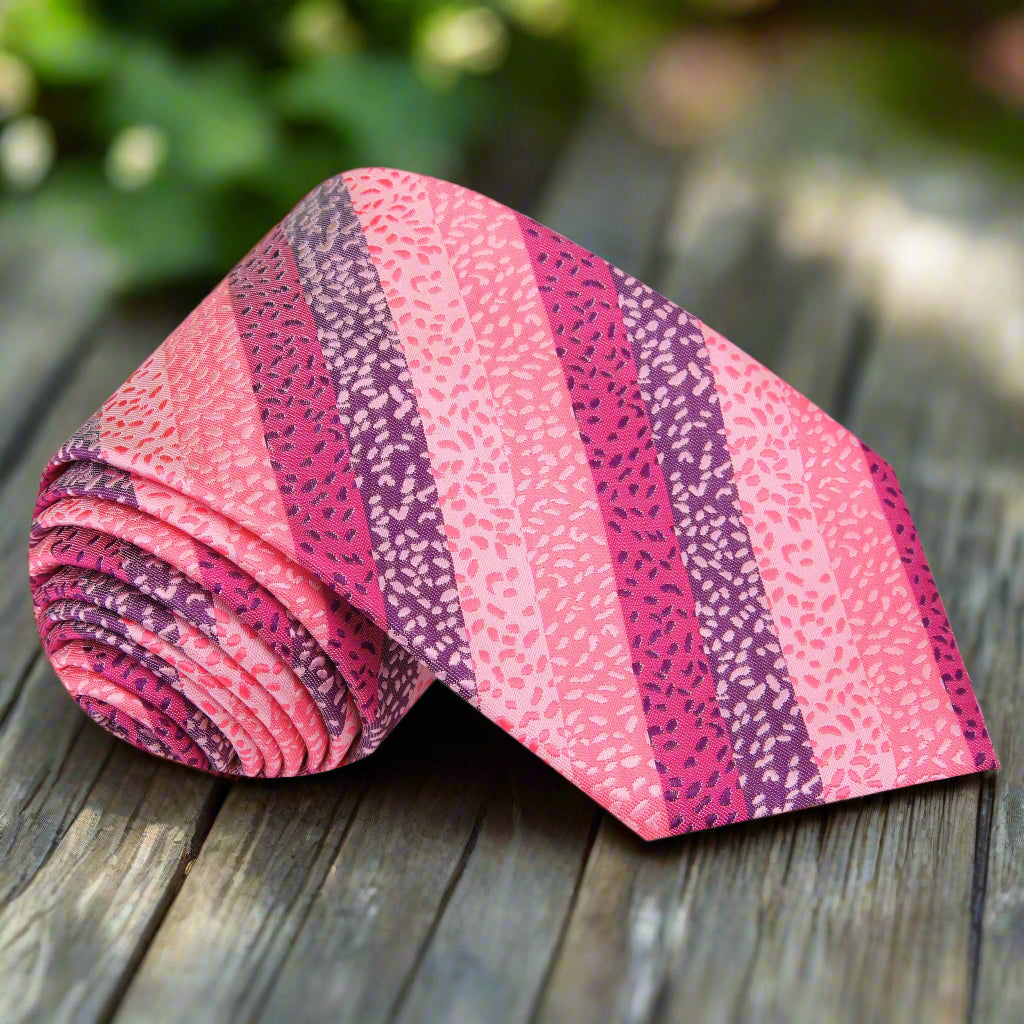 Elegant silk necktie in pink stripes, displayed on a white background.