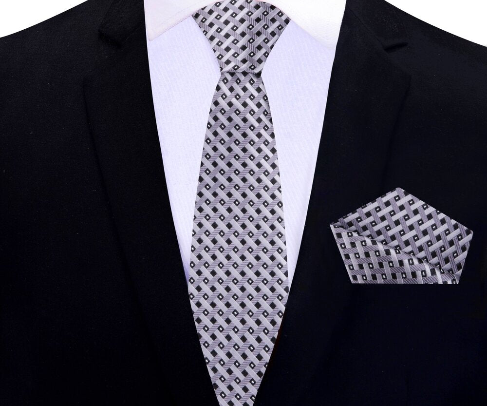Close-up of gold geometric silk tie on a mannequin showing intricate pattern