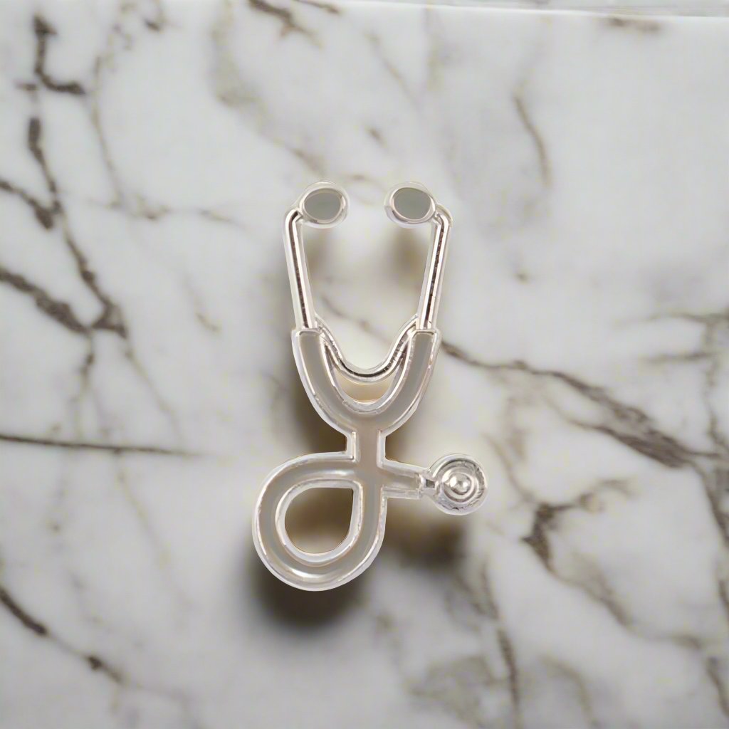 Close-up of the stethoscope lapel pin on a suit jacket, emphasizing its unique design.