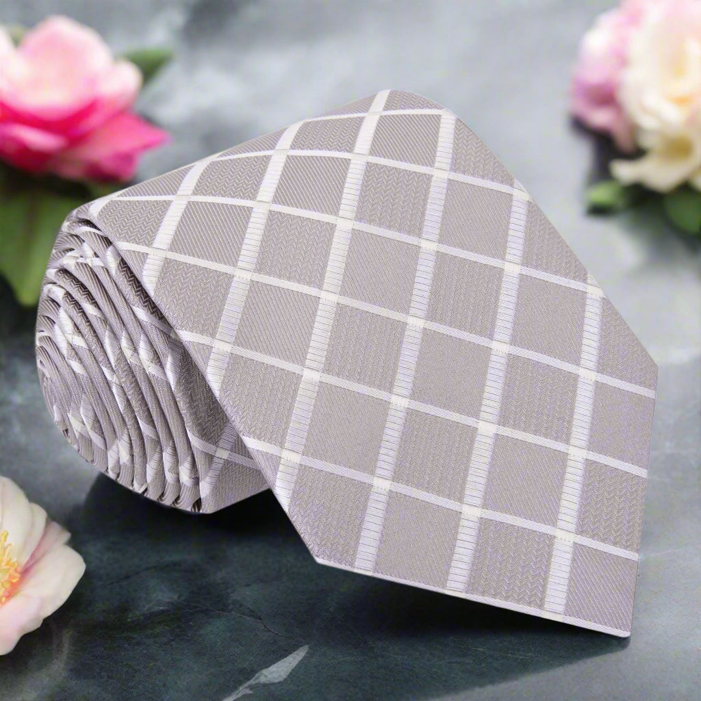 Front view of pearl silk necktie styled with light grey suit for wedding setting.