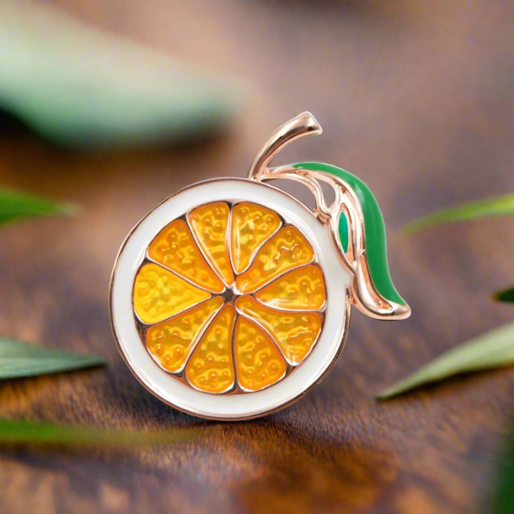 Close-up of the vibrant orange slice enamel pin, showcasing its intricate design.