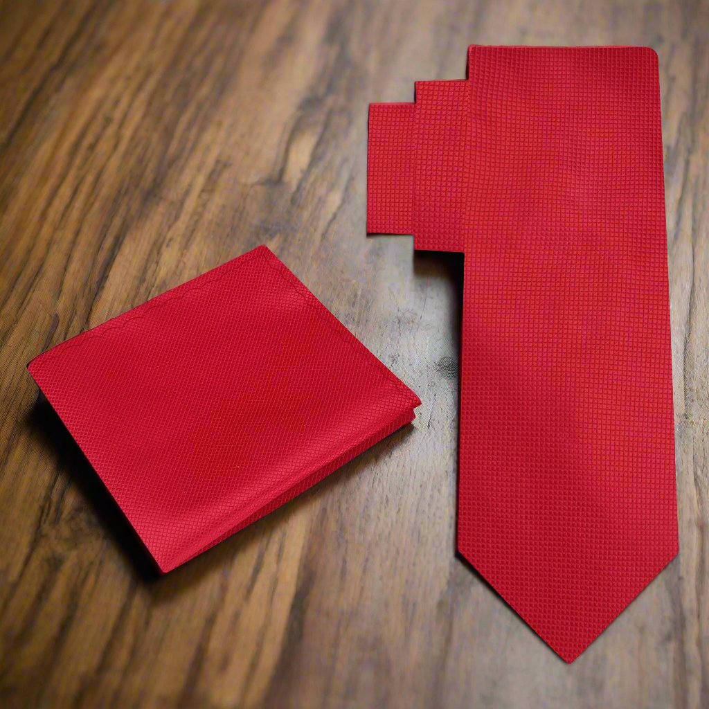 A man wearing a white dress shirt and solid red silk tie for a business or wedding event
