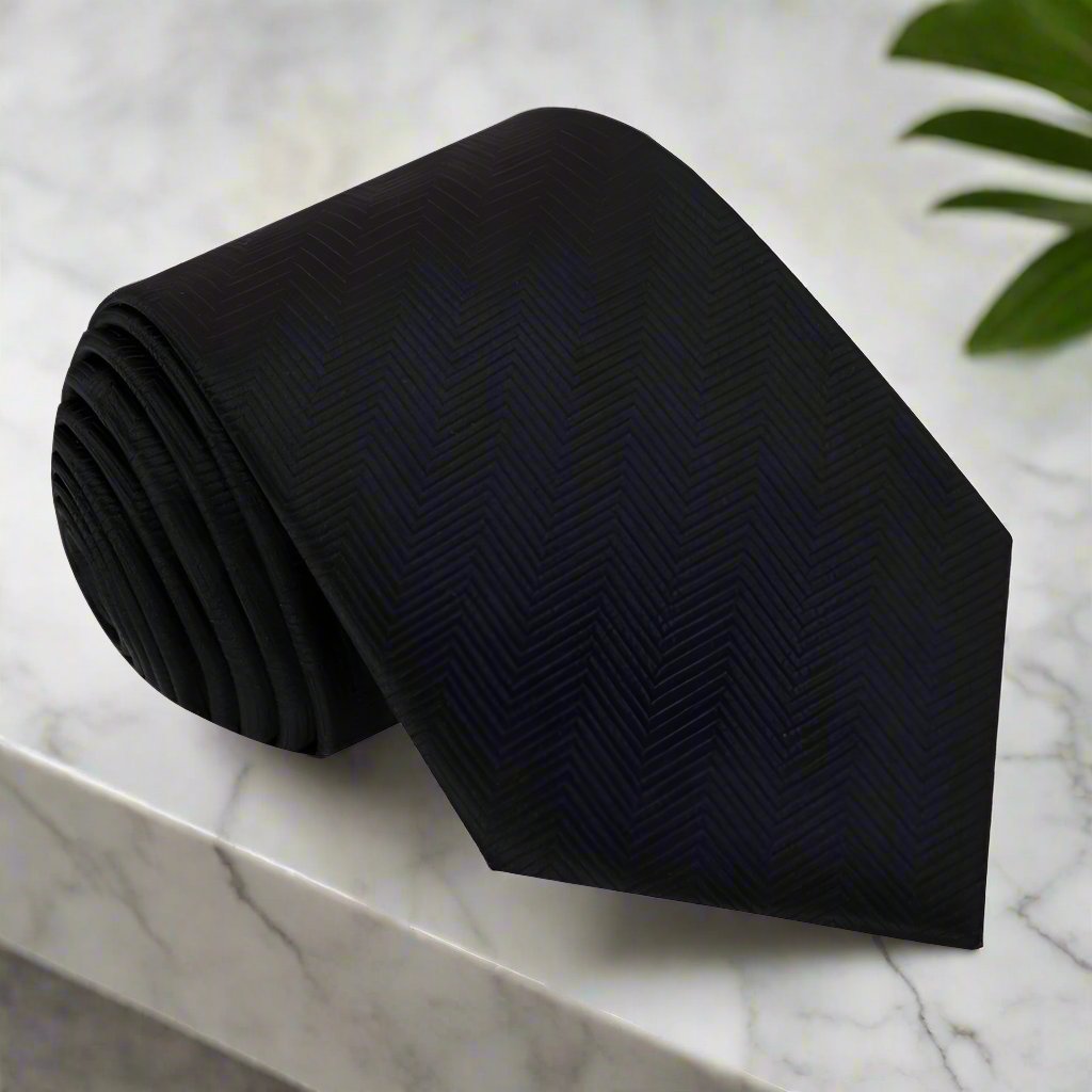 Elegant black silk necktie draped over a formal suit, showcasing its sleek design.