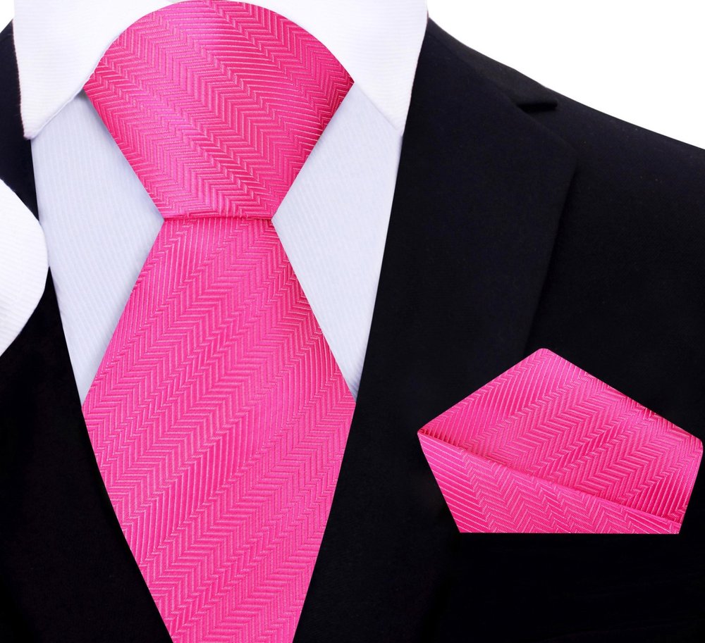 Pocket square matching the pink and purple silk necktie, elegantly folded on a polished wooden surface.