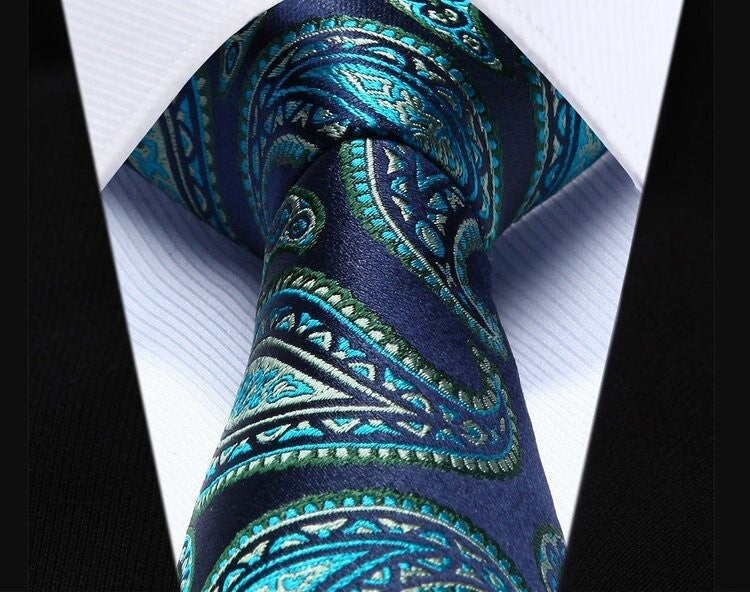 Green paisley silk tie paired with a light grey shirt, ideal for garden weddings.