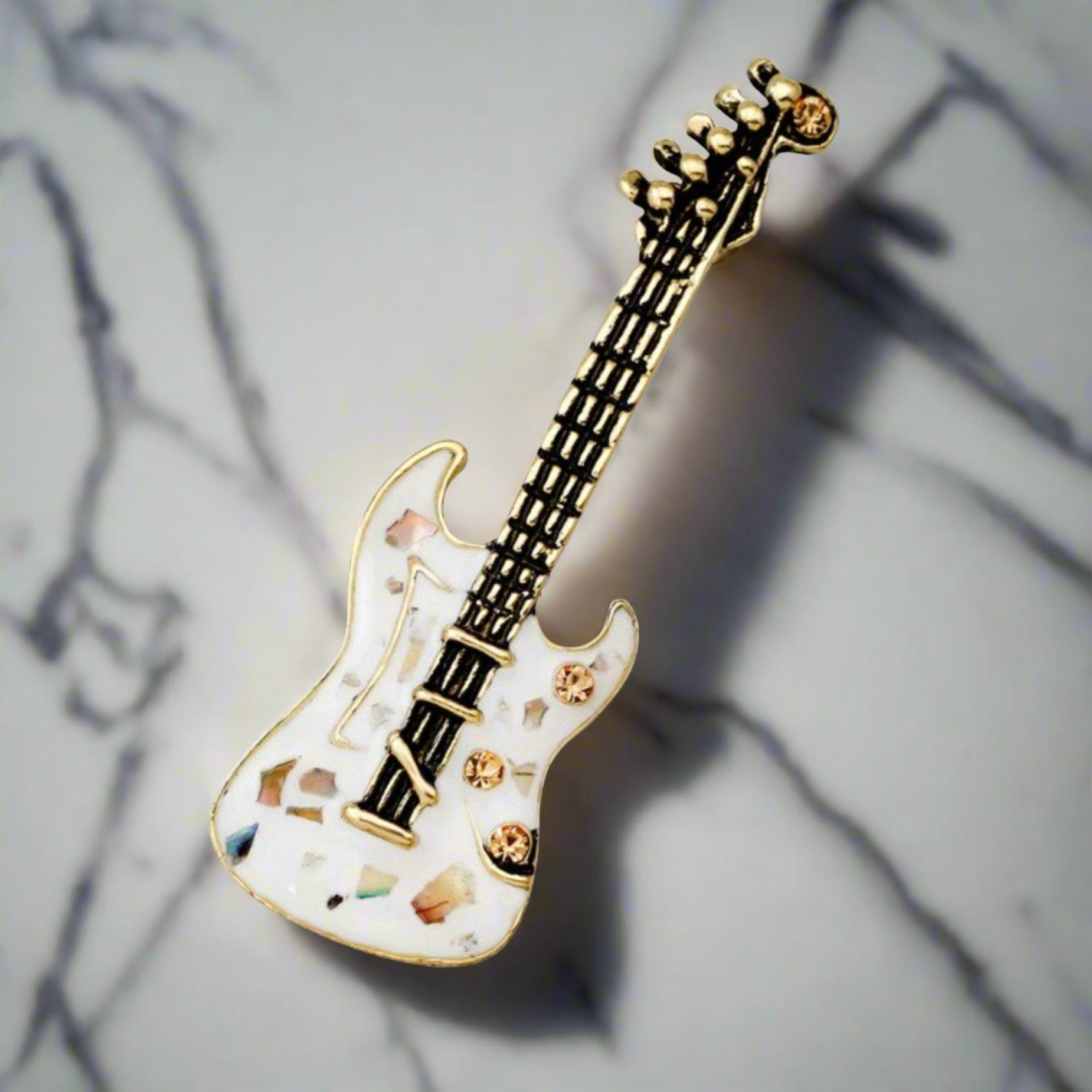 Guitar lapel pin with stones displayed on a stylish jacket