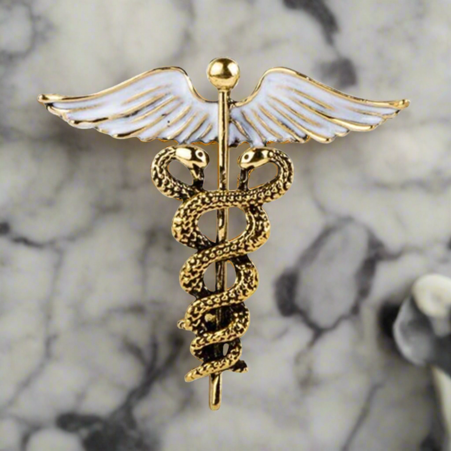 Elegant gold and silver caduceus lapel pin on a suit jacket