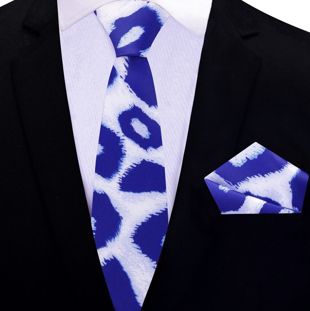 Folded Frostwyke necktie with matching silk pocket square on wooden surface