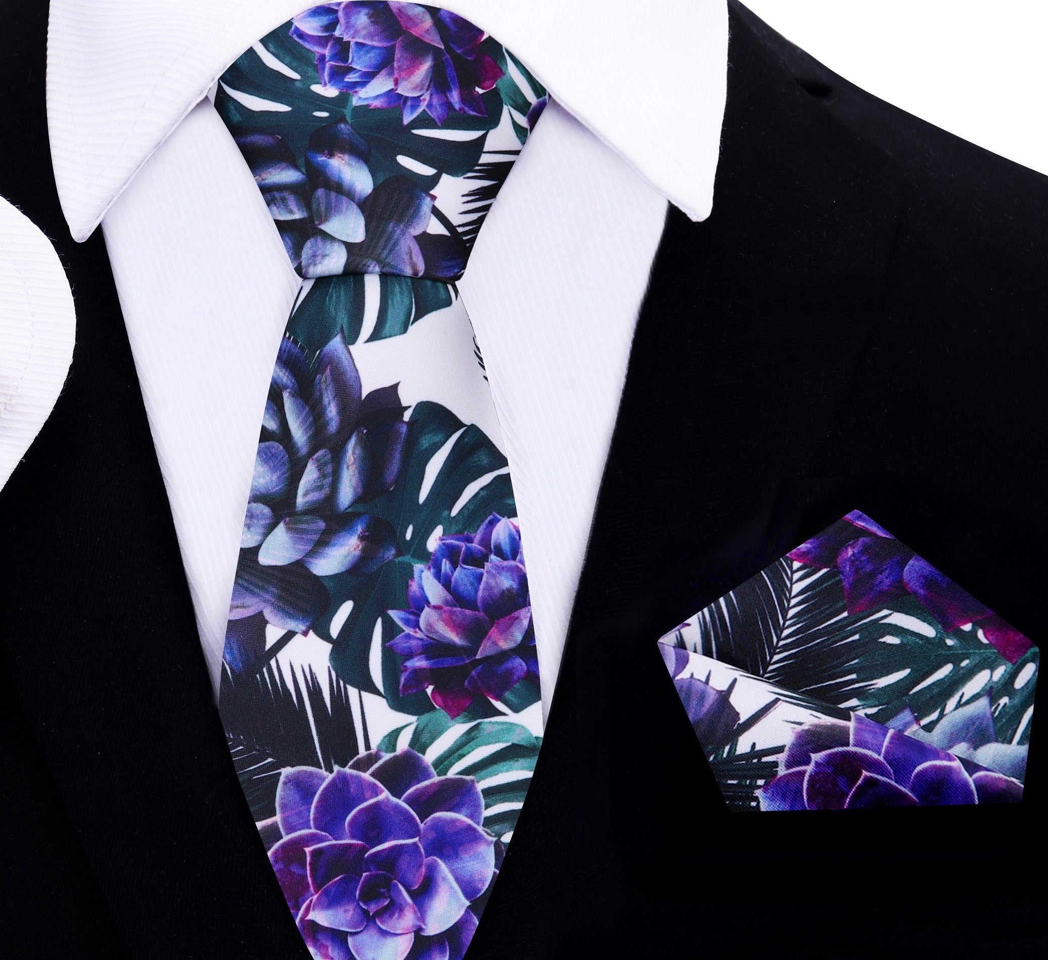 Close-up of a floral silk tie with large leaf and flower pattern in white, green, purple, and black