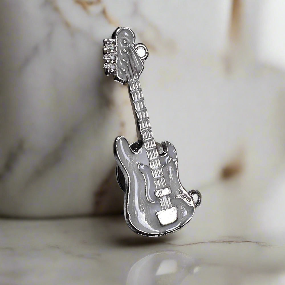 Guitar lapel pin with stones displayed on a stylish jacket