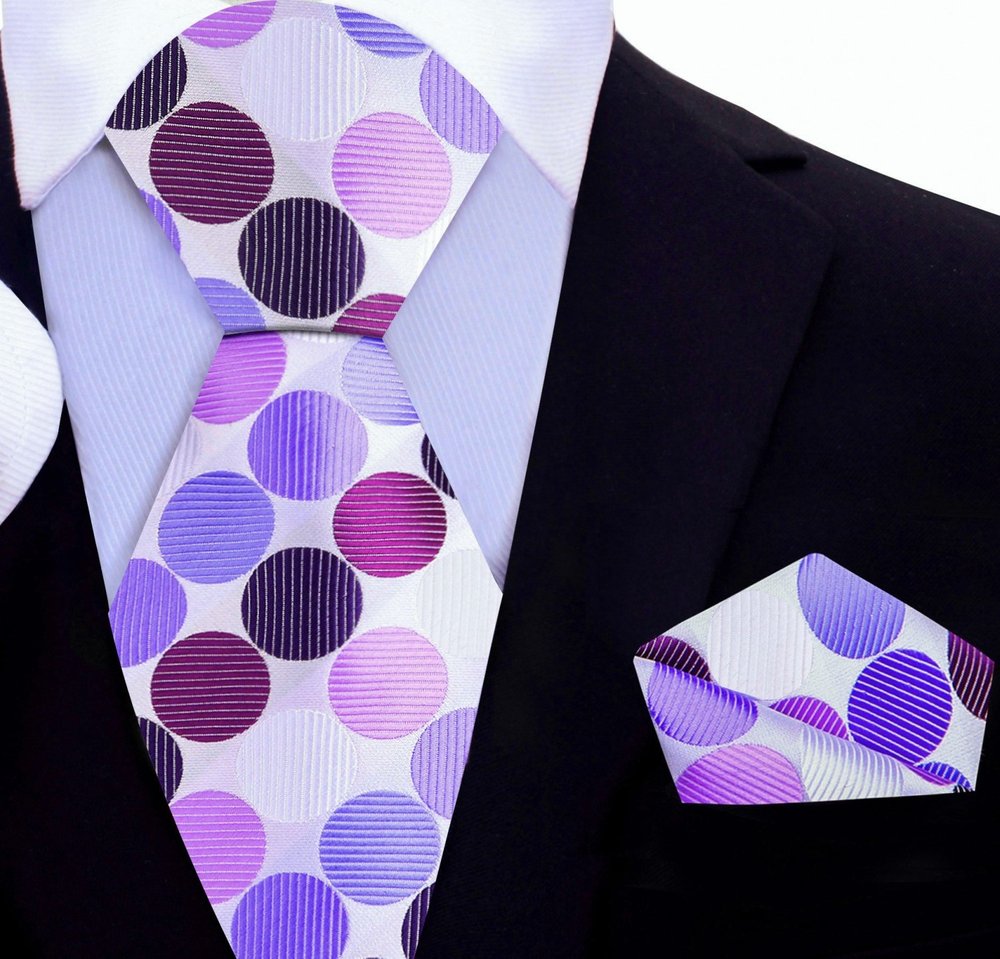 Close-up of the vibrant polka dot silk necktie, emphasizing the texture and quality of the fabric.