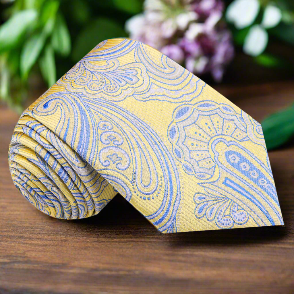 Close-up of a yellow and blue paisley tie with a subtle swirl pattern