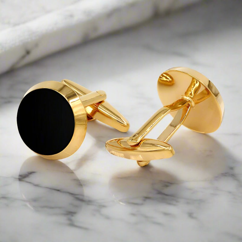Close-up of gold compass cufflinks on a tuxedo sleeve, ideal for formal wear