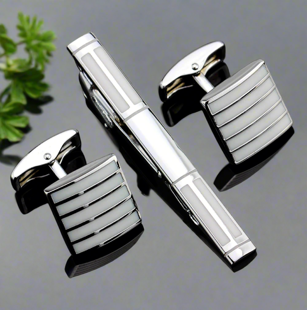 Pearl chrome tie bar and cufflinks set on a formal shirt, close-up view