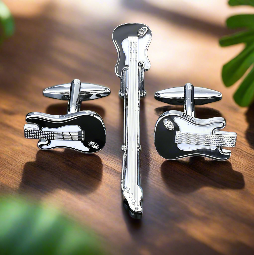 Close-up view of chrome and black guitar cufflinks on a white dress shirt.